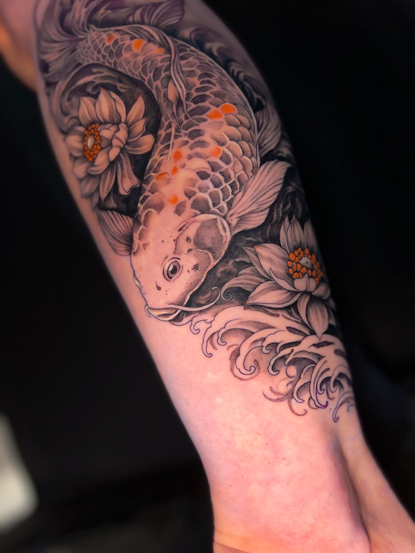 Farbiges Koi Tattoo mit floralen Details auf dem Arm