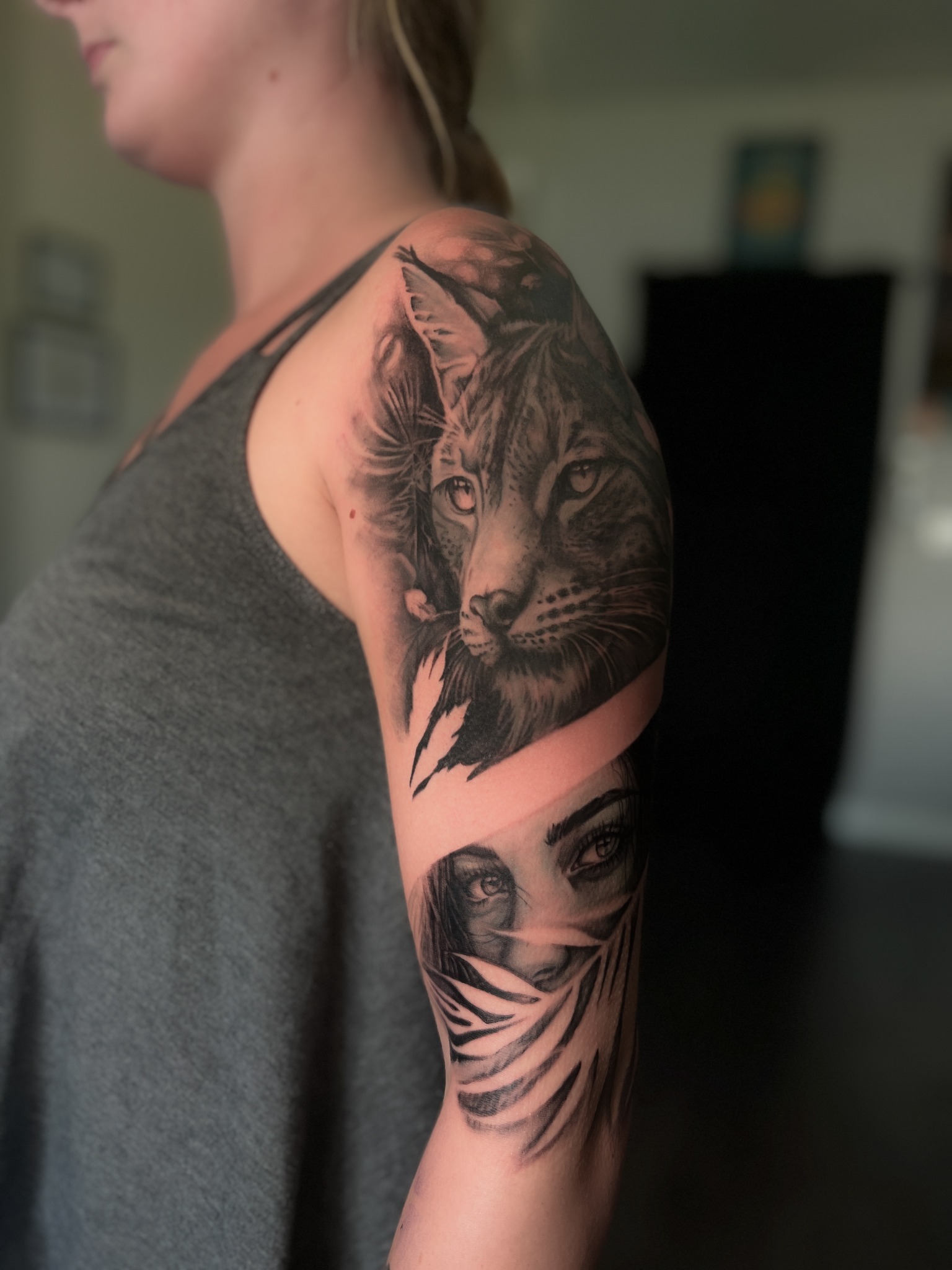 Großes Black & Grey Tattoo mit Luchs und Frauenporträt auf dem Arm